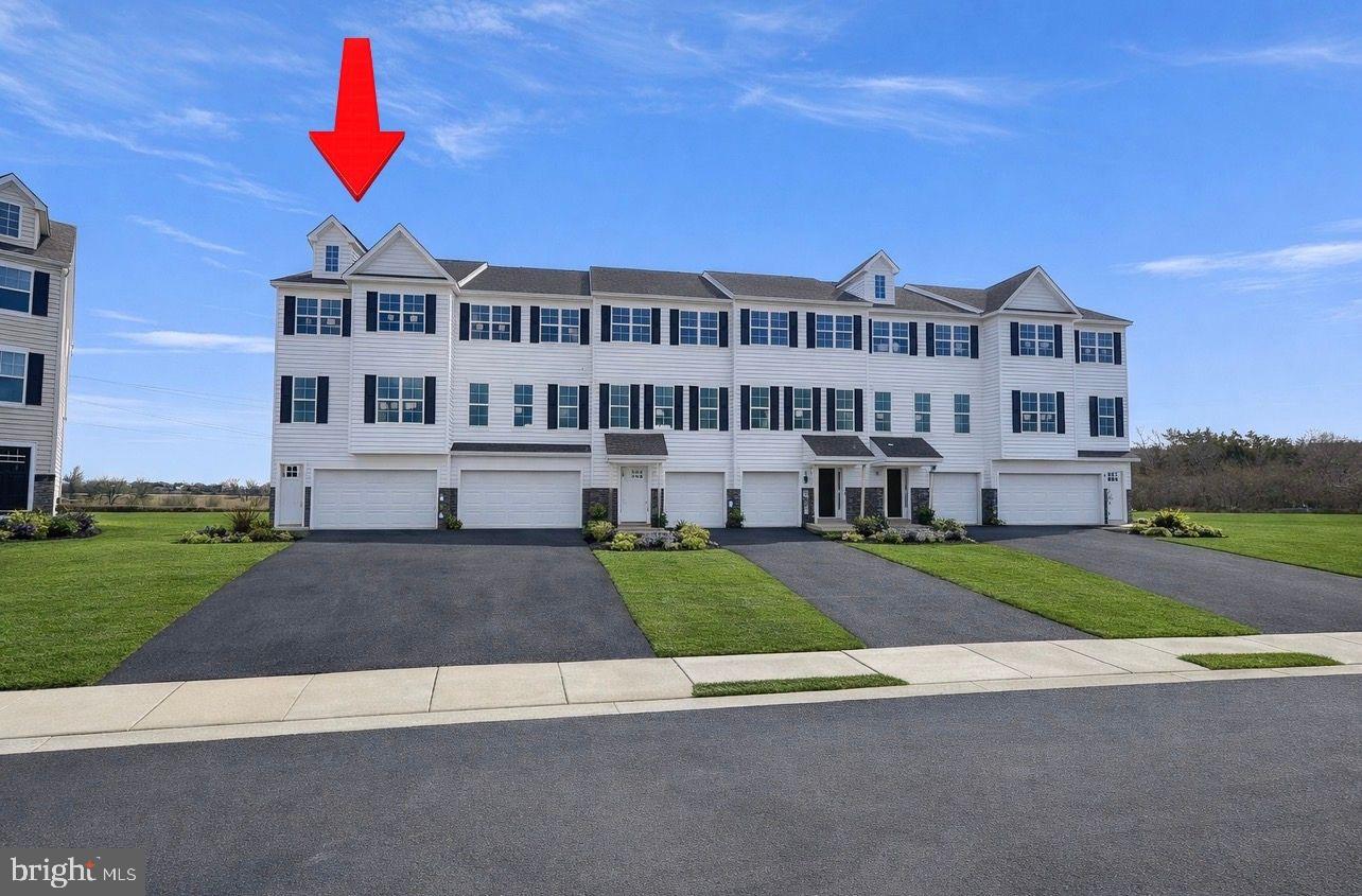 a view of a big house with a yard and plants
