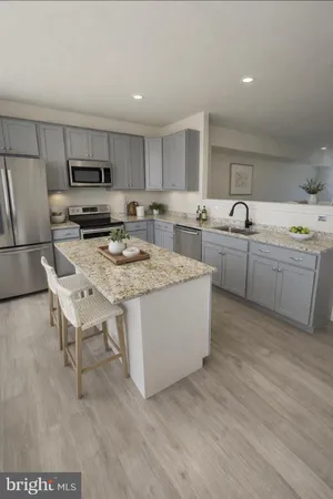 a living room with stainless steel appliances granite countertop furniture a fireplace a flat screen tv and a refrigerator