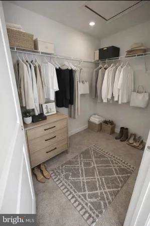 a view of walk in closet with clothes and shoes