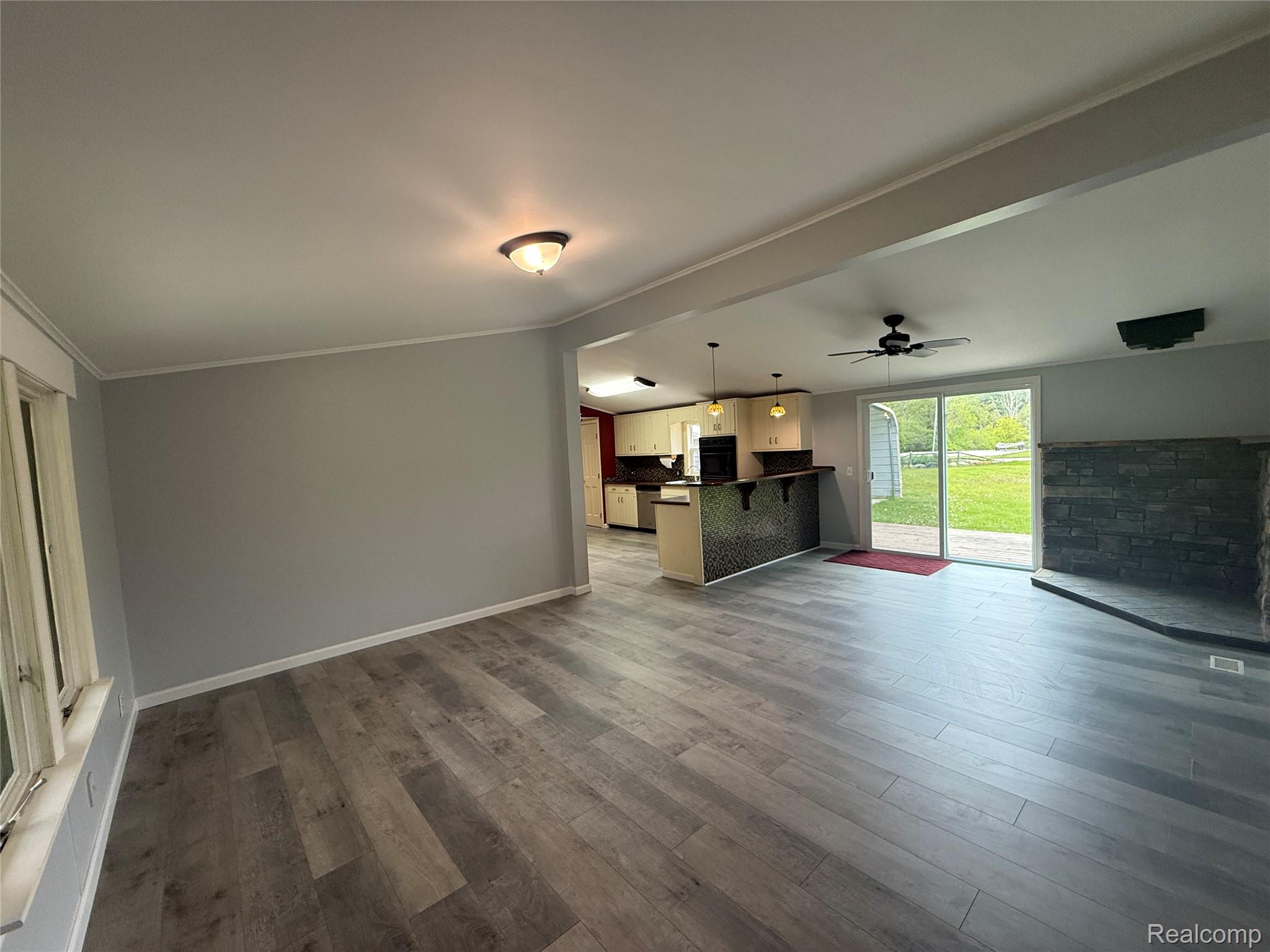 7149-7163 Burpee Road Grand Blanc, MI 48439 - Photo 26 of 72 Unfurnished living room with dark wood-type flooring, ceiling fan, crown molding, and lofted ceiling