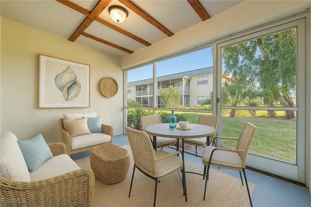 a dining room with furniture and a floor to ceiling window