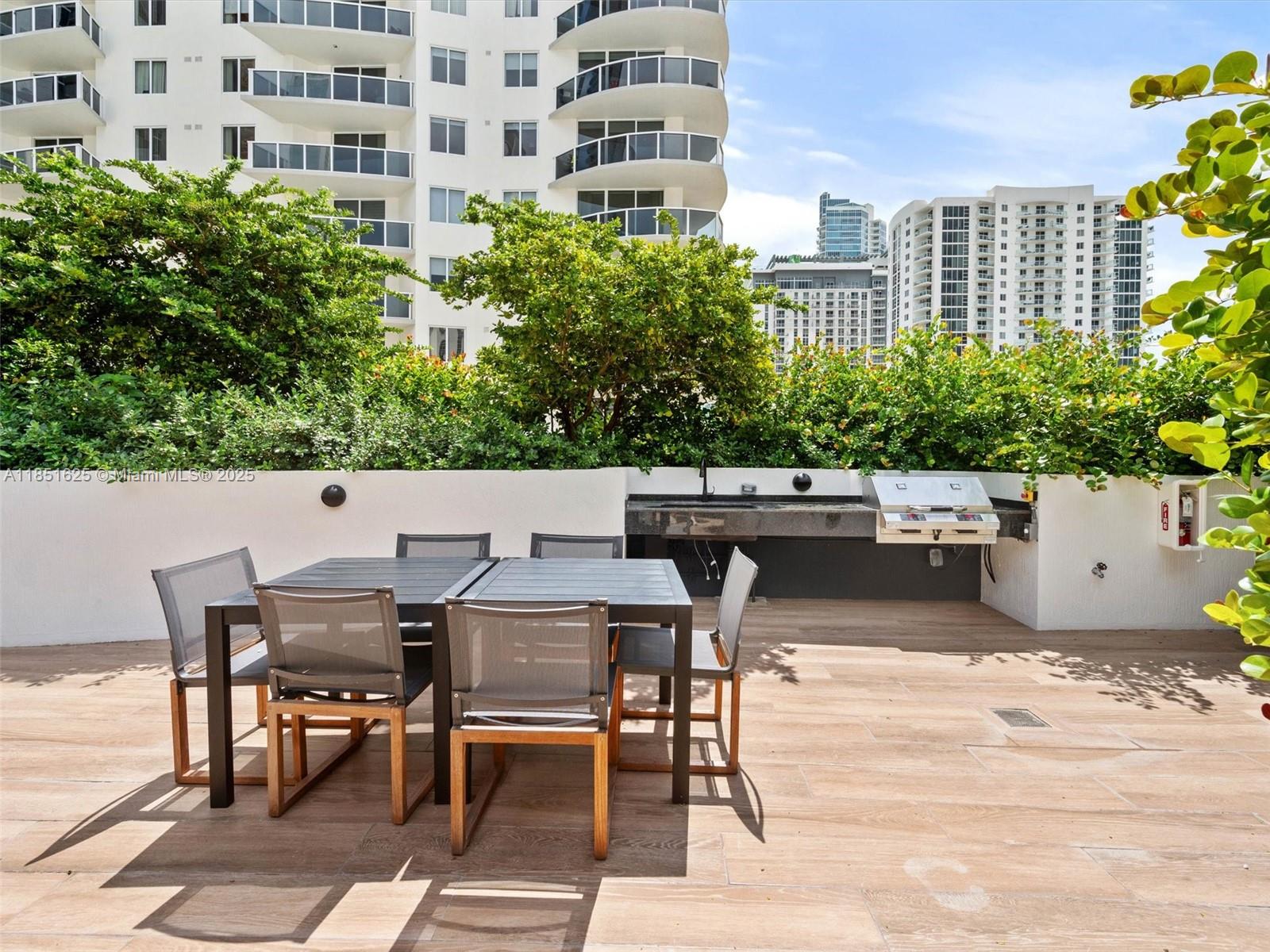 700 Northeast 24th Street, Unit 4305 Miami, FL 33137 - Photo 25 of 54 a view of a patio with table and chairs and potted plants