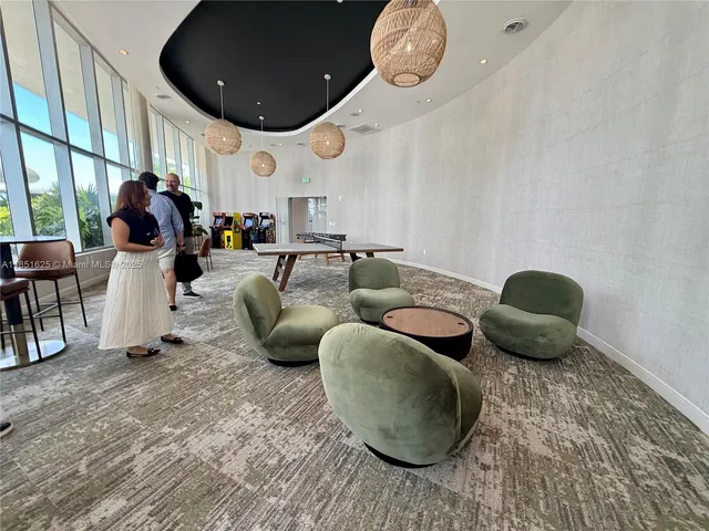 a view of swimming pool with lounge chair and palm trees