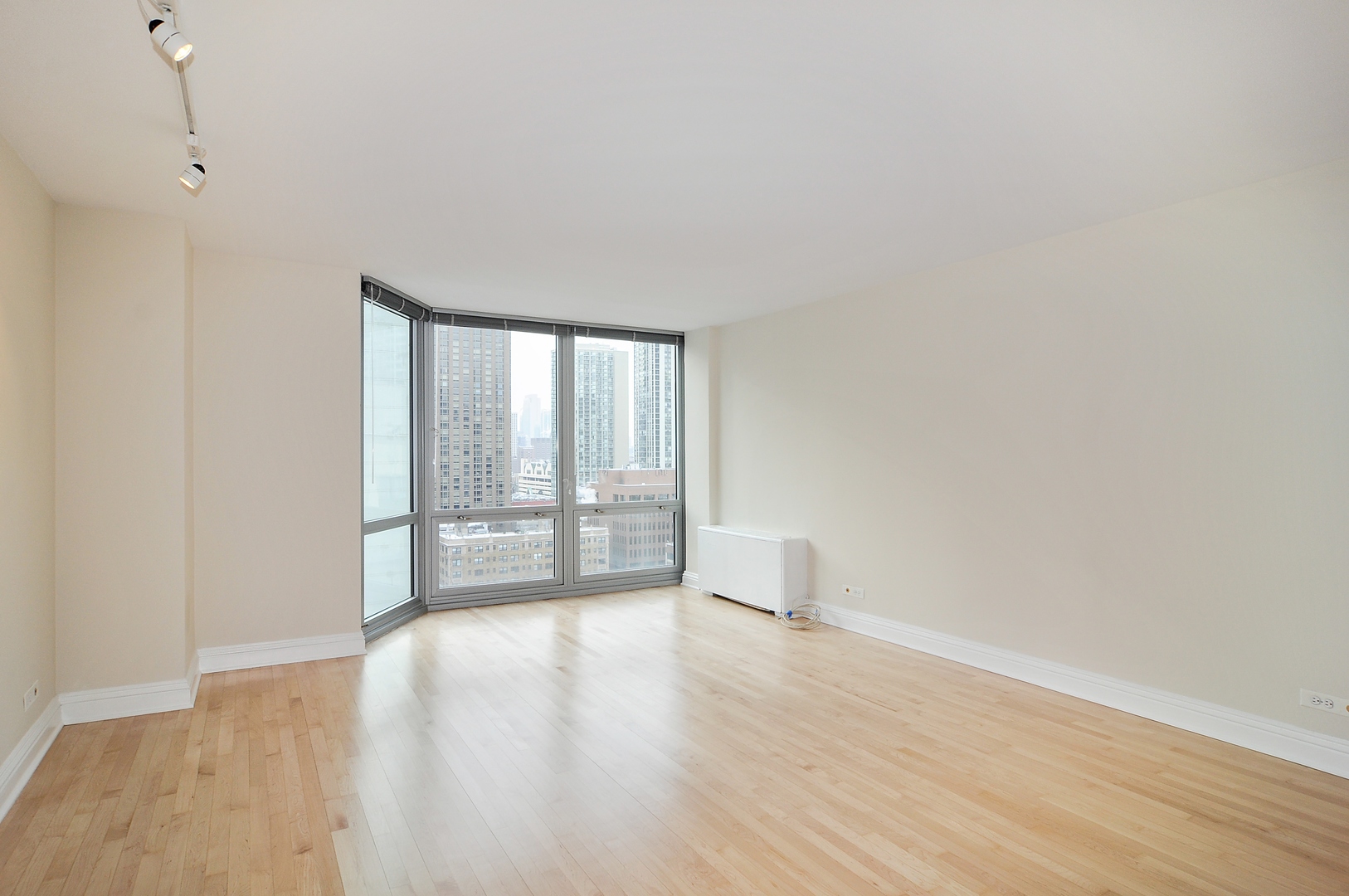 21 West Goethe Street, Unit 16K Chicago, IL 60610 - Photo 2 of 10 a view of an empty room with wooden floor and a window