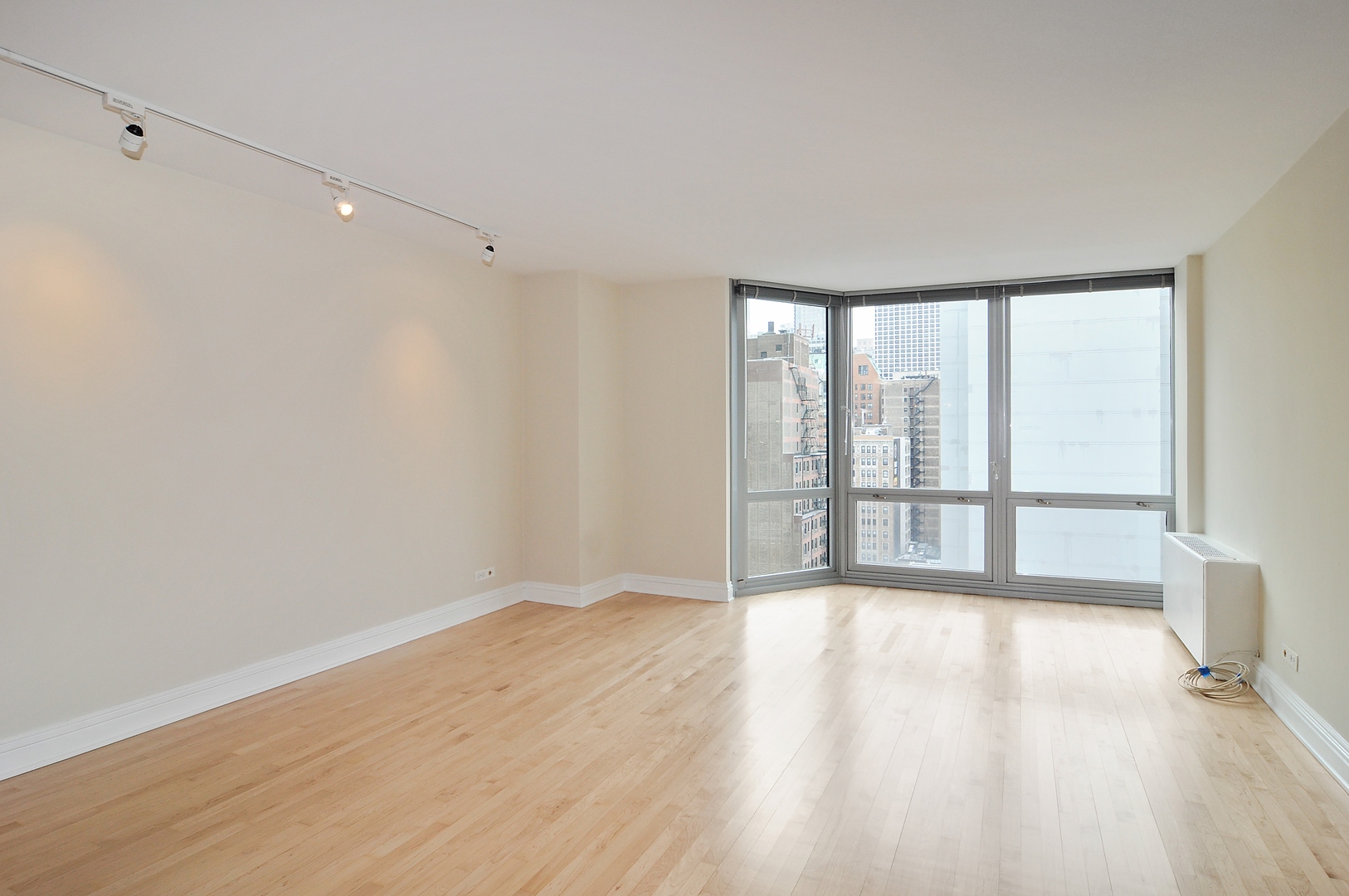 21 West Goethe Street, Unit 16K Chicago, IL 60610 - Photo 3 of 10 a view of an empty room with wooden floor and a window