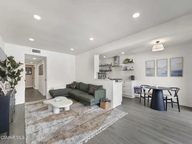 a living room with furniture and a dining table with kitchen view