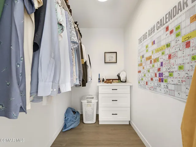 a view of walk in closet with clothes and shoes
