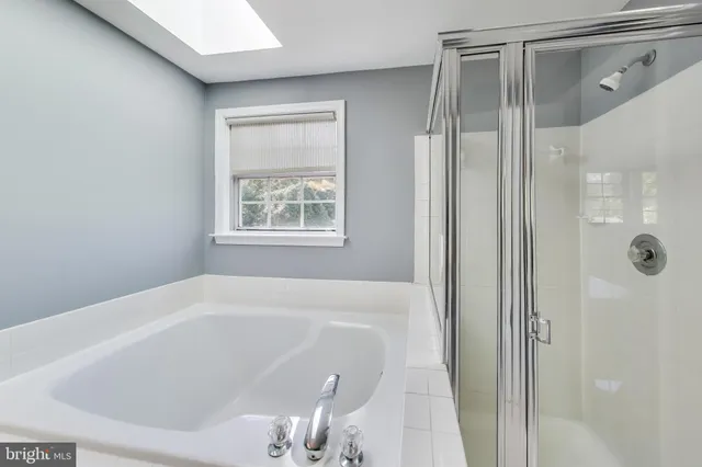 a white bath tub sitting next to a shower