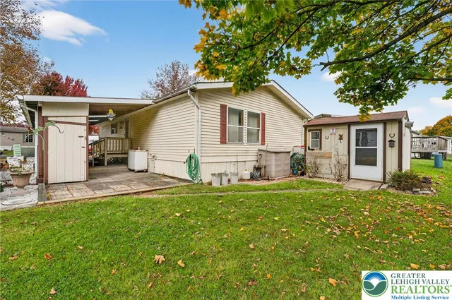 a view of a house with a yard and wooden fence