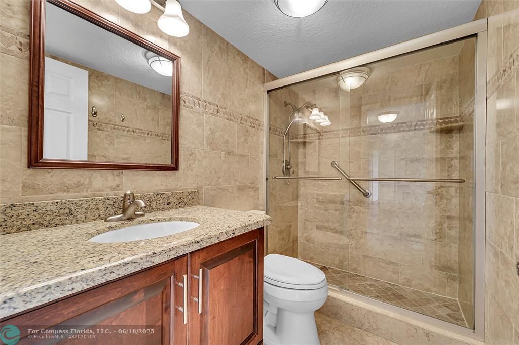 10777 West Sample Road, Unit 805 Coral Springs, FL 33065 - Photo 13 of 34 a bathroom with a granite countertop sink toilet and shower
