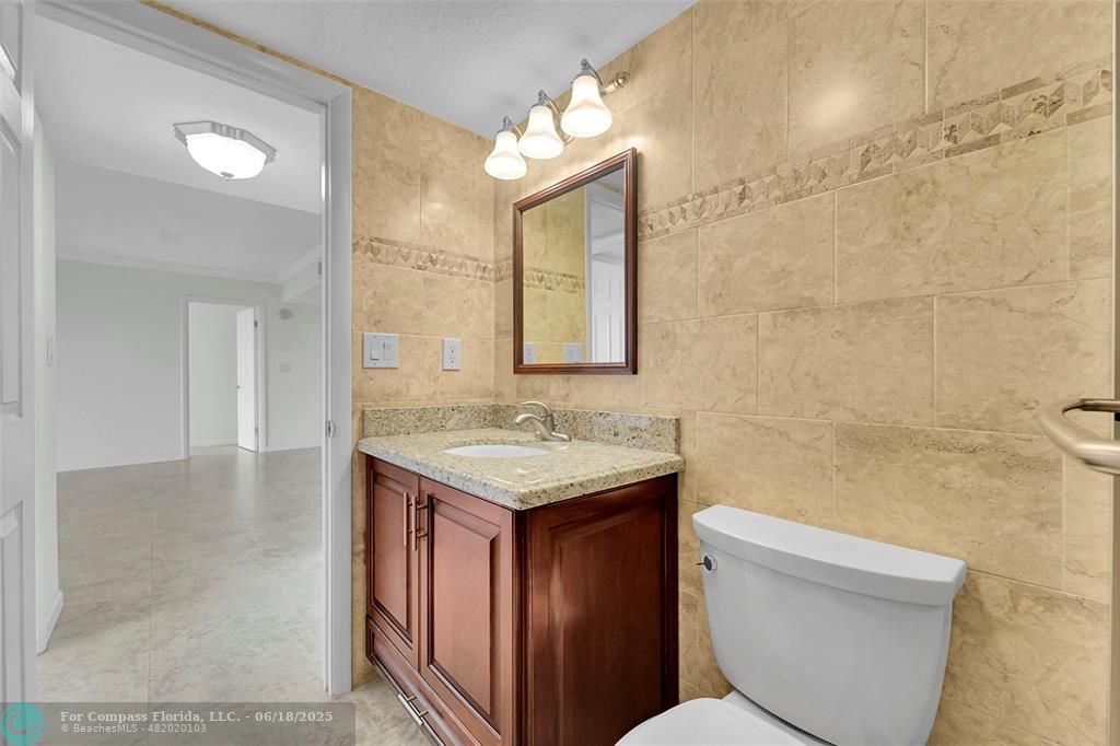 10777 West Sample Road, Unit 805 Coral Springs, FL 33065 - Photo 14 of 34 a bathroom with a granite countertop toilet sink and mirror