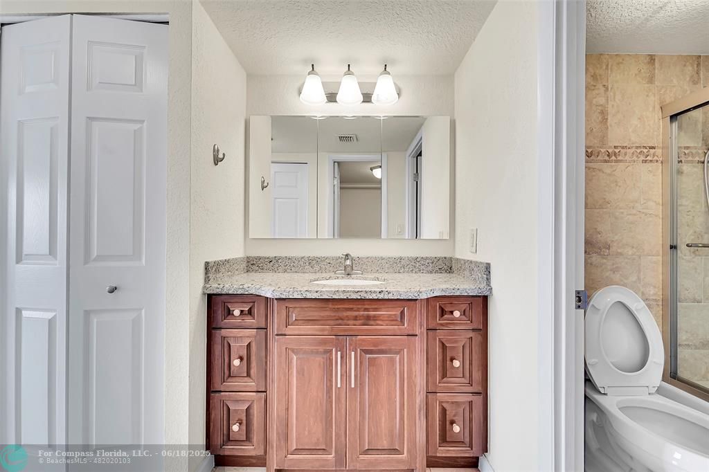10777 West Sample Road, Unit 805 Coral Springs, FL 33065 - Photo 19 of 34 a bathroom with a granite countertop sink and a mirror