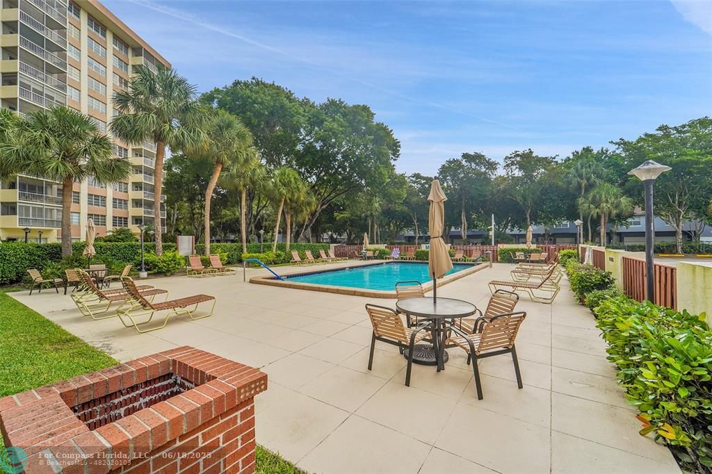 10777 West Sample Road, Unit 805 Coral Springs, FL 33065 - Photo 31 of 34 a swimming pool with outdoor seating and yard