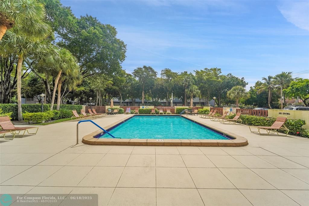 10777 West Sample Road, Unit 805 Coral Springs, FL 33065 - Photo 33 of 34 a view of a swimming pool with an outdoor space and seating area