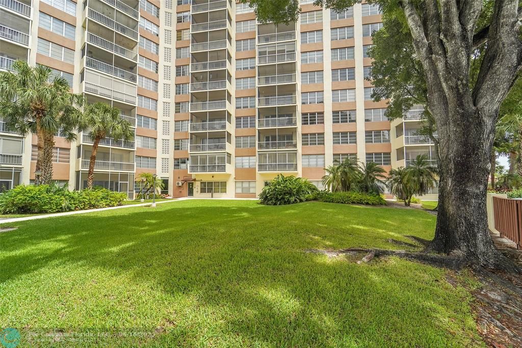 10777 West Sample Road, Unit 805 Coral Springs, FL 33065 - Photo 34 of 34 a view of a backyard with plants and large trees