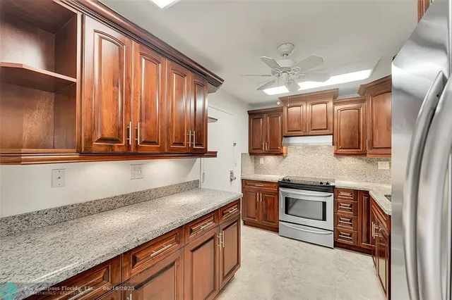 a kitchen with stainless steel appliances granite countertop a sink a stove and a refrigerator