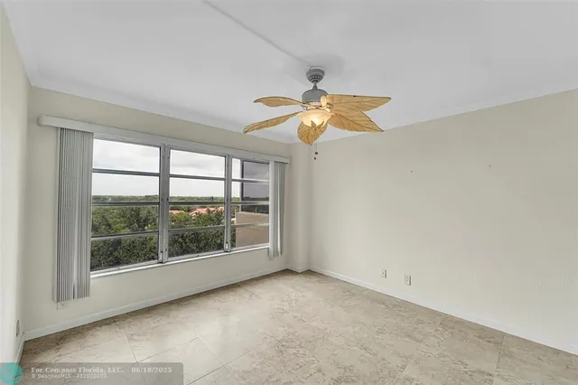 an empty room with windows and fan