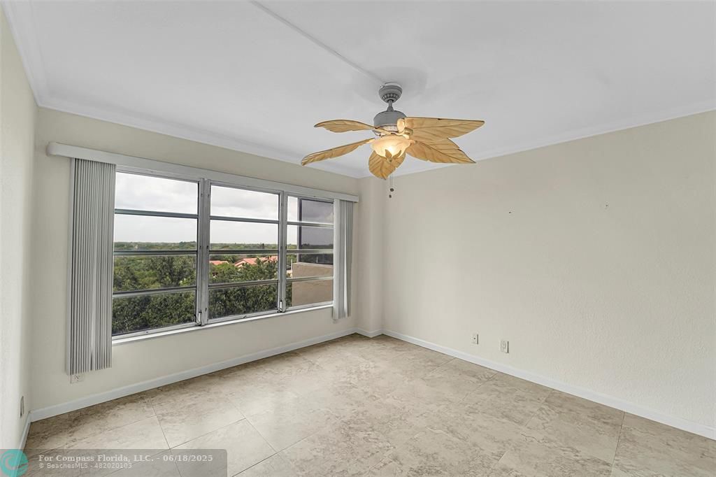 10777 West Sample Road, Unit 805 Coral Springs, FL 33065 - Photo 10 of 34 an empty room with windows and fan