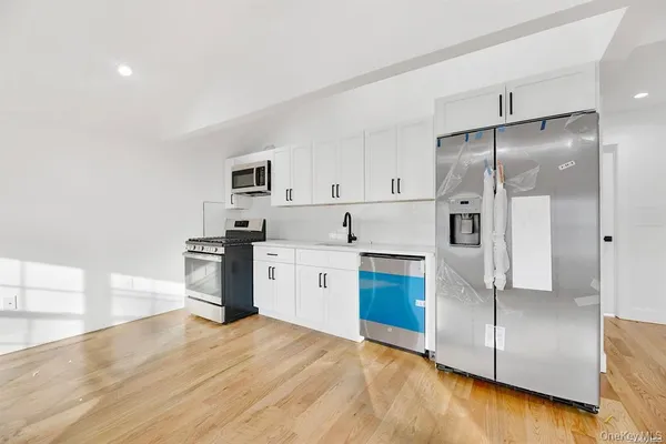 a kitchen with granite countertop a refrigerator and a sink