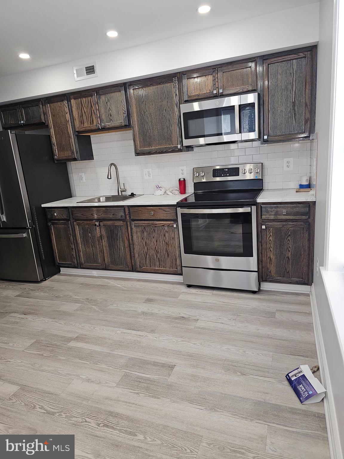 802 Allen Street Cambridge, MD 21613 - Photo 12 of 13 a kitchen with stainless steel appliances a stove a microwave and cabinets