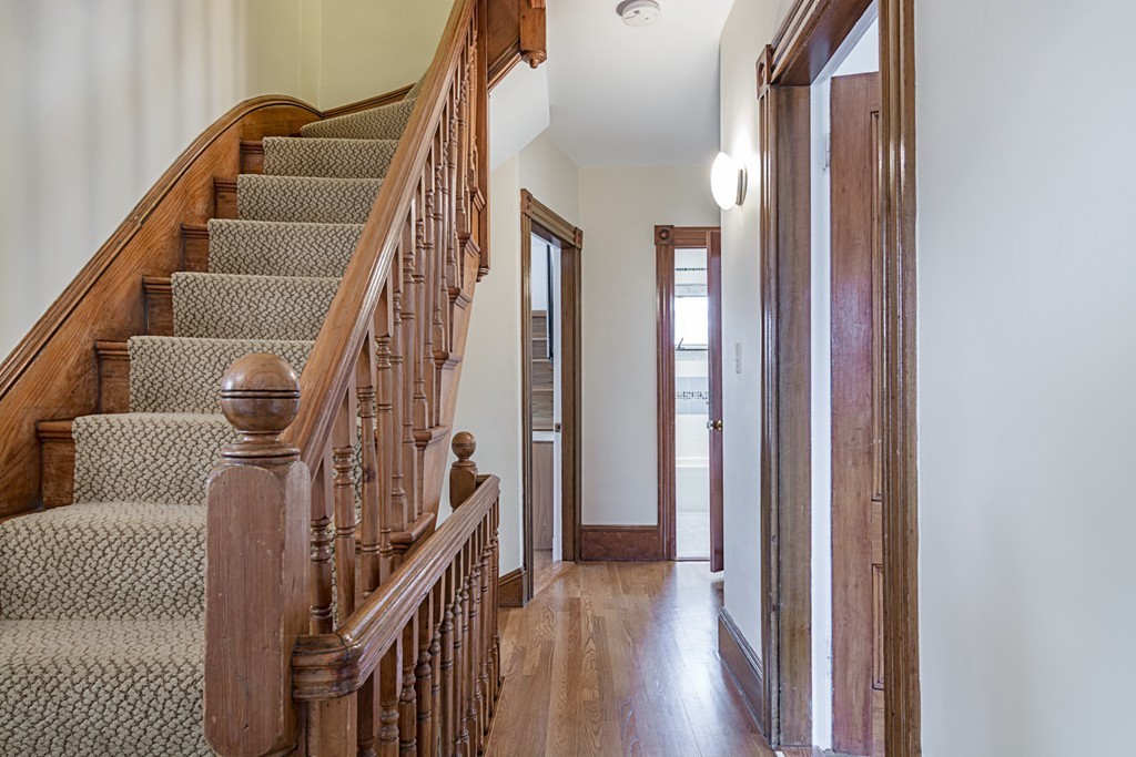 7 Raymond Street Lexington, MA 02421 - Photo 14 of 22 a view of staircase with lots of frames on wall and wooden floor