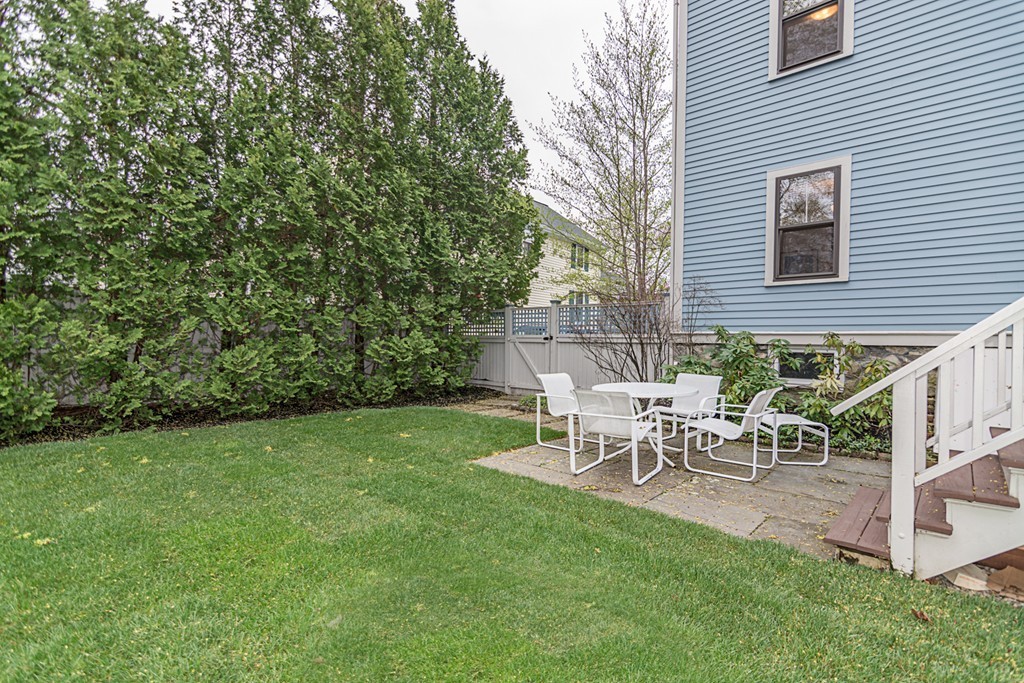 7 Raymond Street Lexington, MA 02421 - Photo 20 of 22 a view of a backyard with table and chairs and a tree