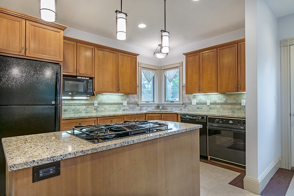 7 Raymond Street Lexington, MA 02421 - Photo 7 of 22 a kitchen with granite countertop stainless steel appliances and wooden cabinets