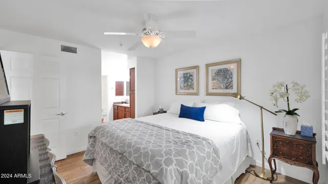 a bedroom with a large bed and a chandelier