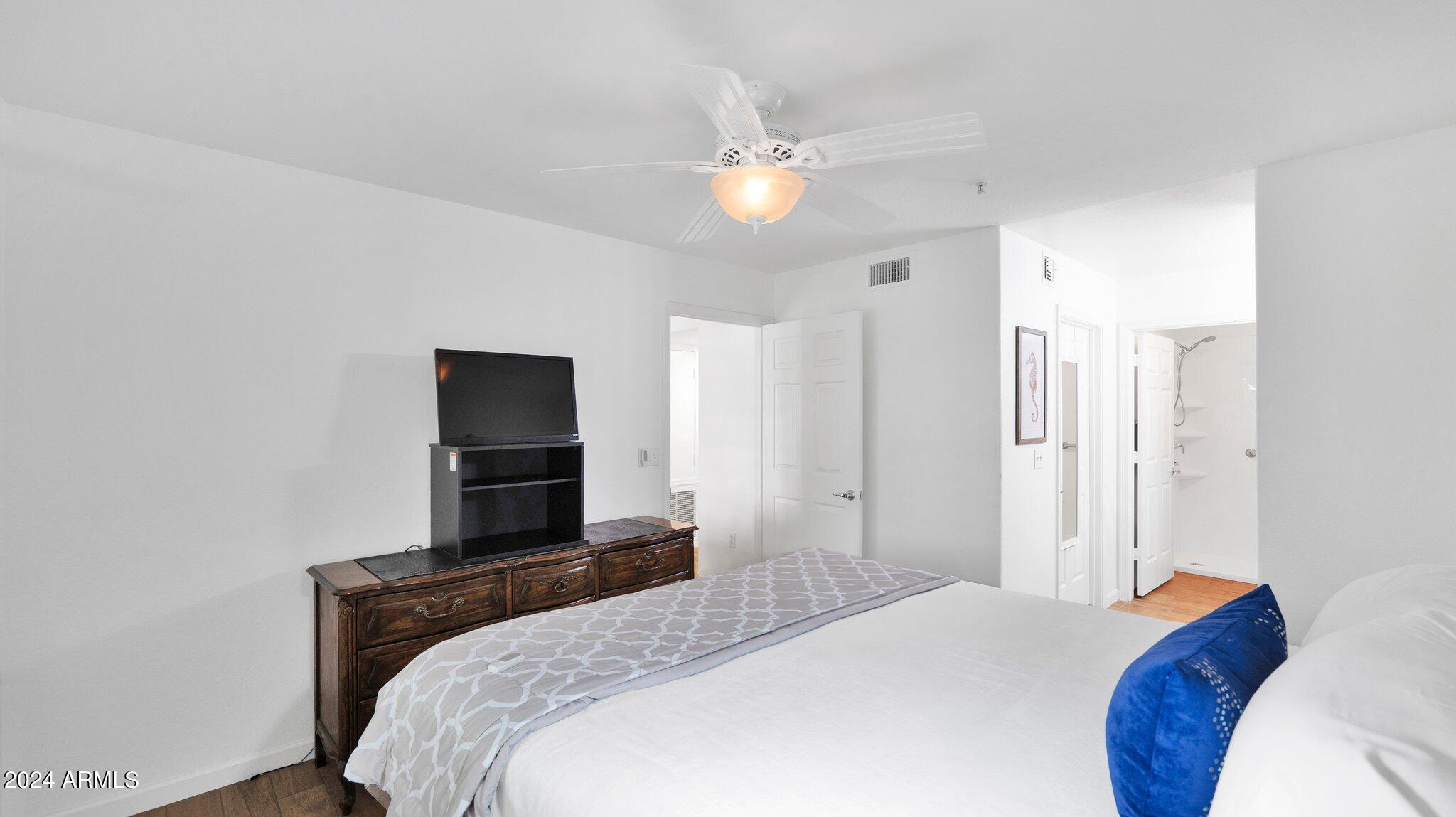 9990 North Scottsdale Road, Unit 1043 Paradise Valley, AZ 85253 - Photo 16 of 28 a bedroom with a bed and a chandelier