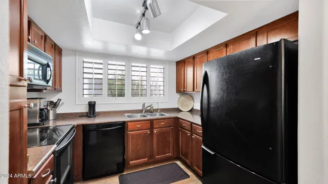 a kitchen with stainless steel appliances granite countertop a refrigerator a sink a stove and a microwave