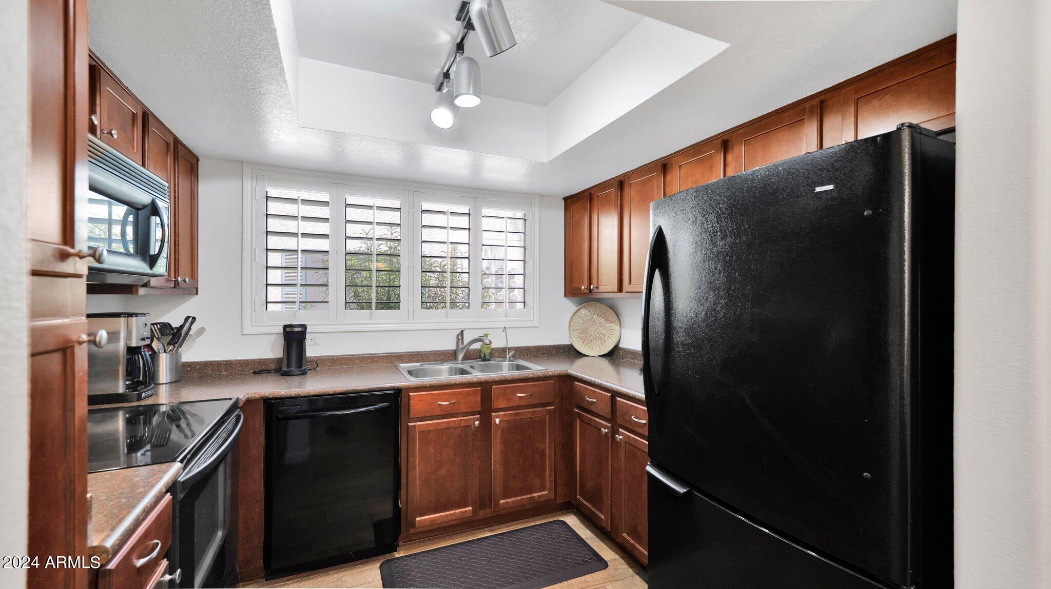 9990 North Scottsdale Road, Unit 1043 Paradise Valley, AZ 85253 - Photo 10 of 28 a kitchen with stainless steel appliances granite countertop a refrigerator a sink a stove and a microwave