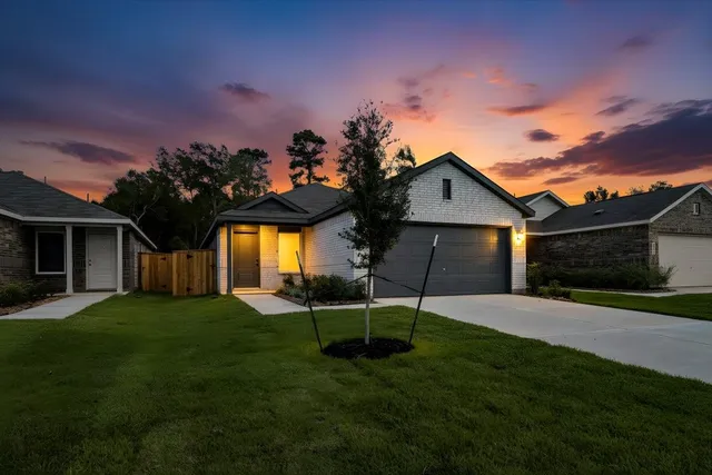 a front view of a house with a yard and trees