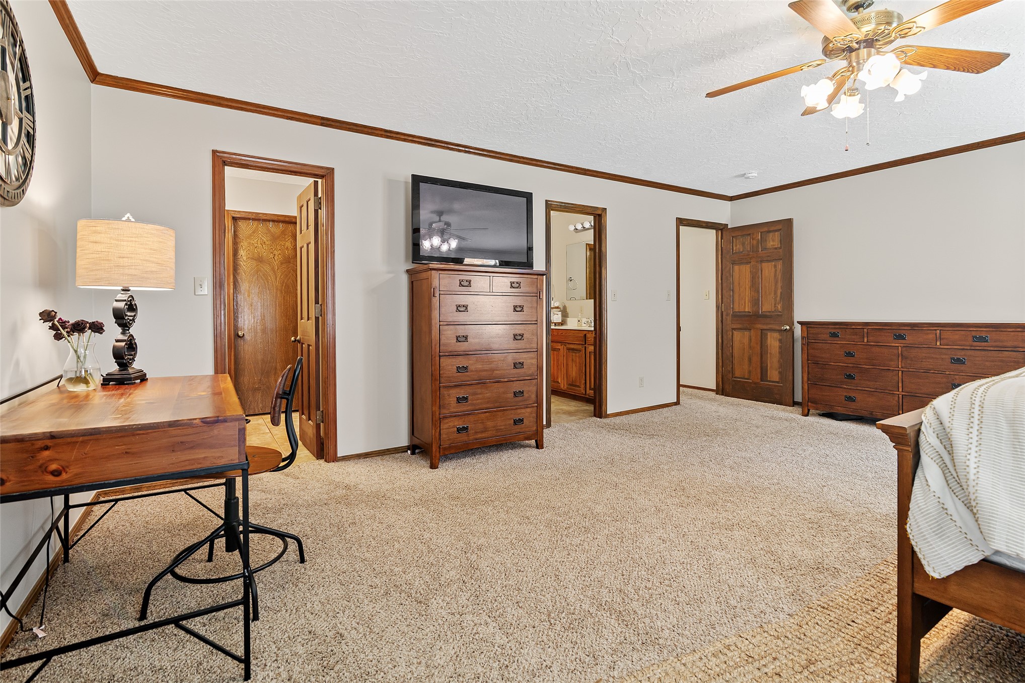 9644 19th Road Nowata, OK 74048 - Photo 13 of 36 Expansive carpeted room featuring a ceiling fan with integrated lighting, wood-finish trim, and multiple doorways