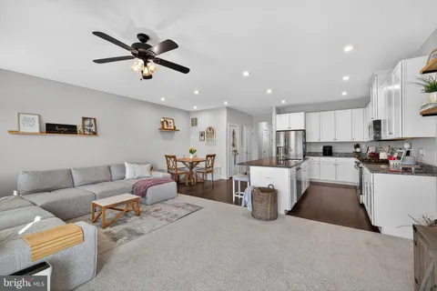 a living room with furniture and kitchen view