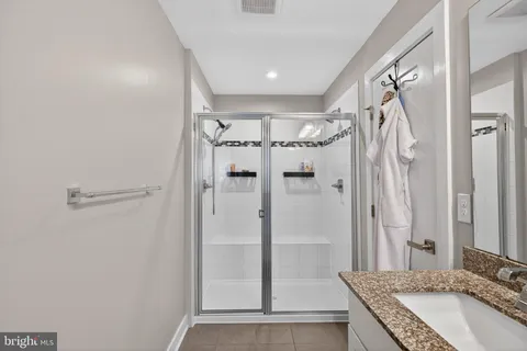 a bathroom with a granite countertop sink mirror vanity and toilet