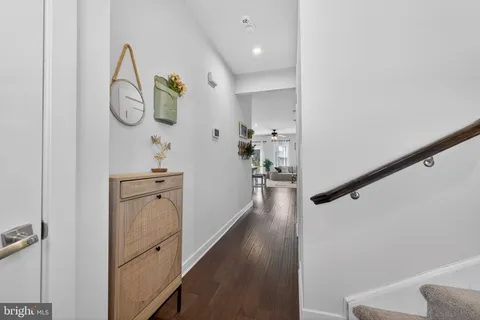 a view of a hallway with wooden floor and entryway