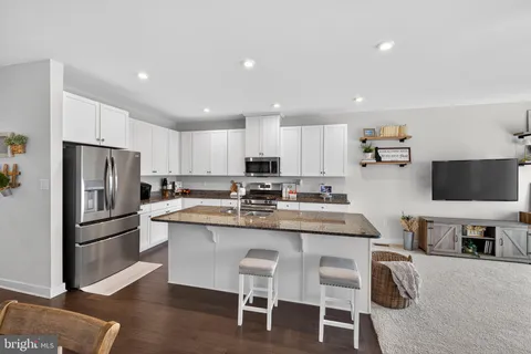 a kitchen with kitchen island granite countertop a sink stove and refrigerator