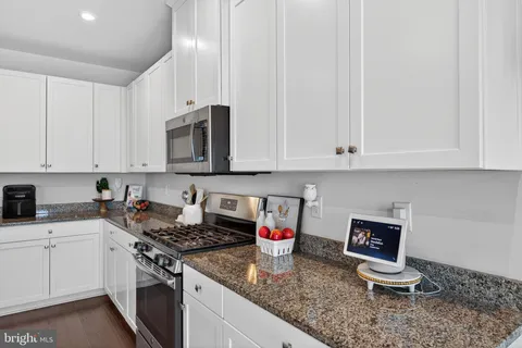 a kitchen with white cabinets and appliances