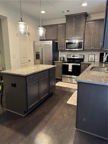 a kitchen with stainless steel appliances a stove sink microwave and cabinets