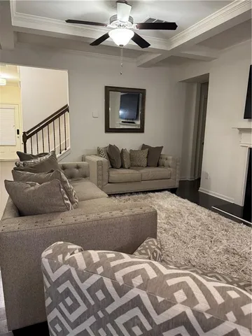 a living room with furniture and a ceiling fan
