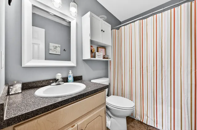 a bathroom with a toilet a sink and mirror