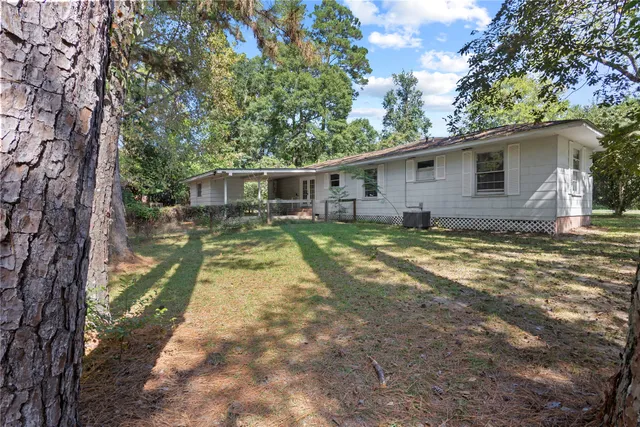 a big yard with trees in front of it