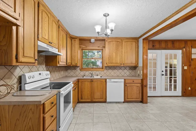 a kitchen with stainless steel appliances granite countertop a sink a stove a refrigerator and cabinets