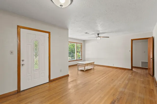 an empty room with wooden floor and windows