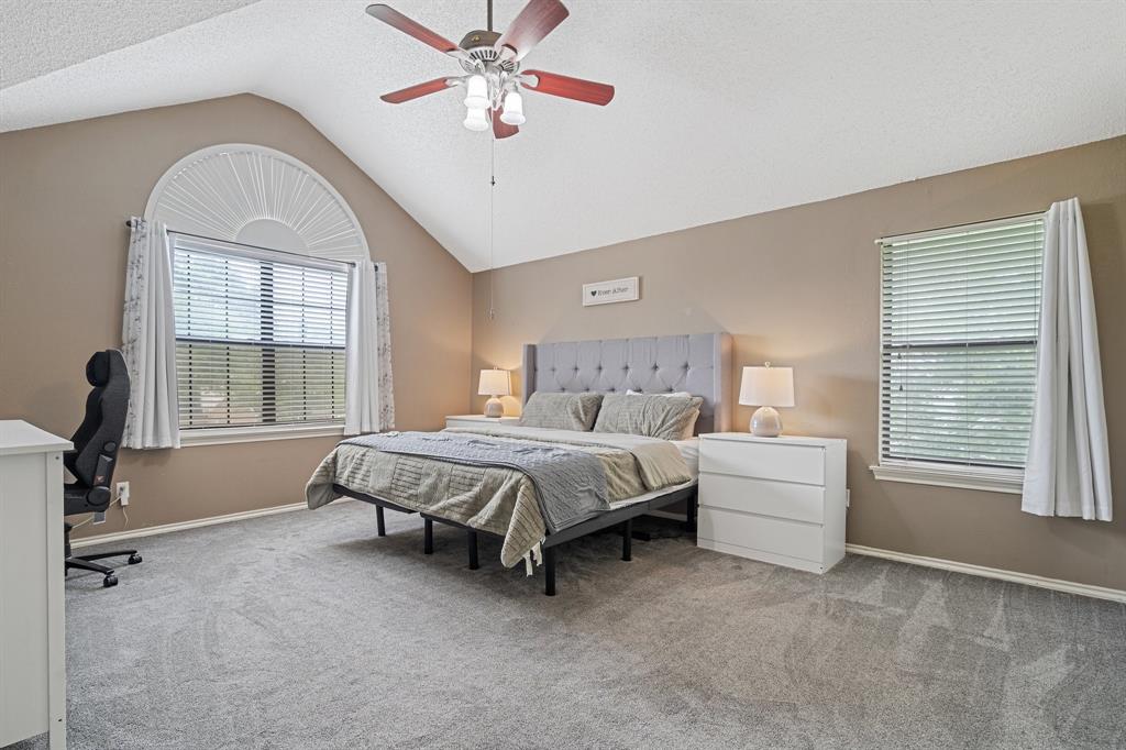 303 Hopewell Street Grand Prairie, TX 75052 - Photo 16 of 28 a spacious bedroom with a bed and a chandelier