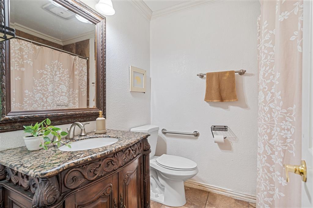 303 Hopewell Street Grand Prairie, TX 75052 - Photo 22 of 28 a bathroom with a granite countertop sink a toilet and a mirror
