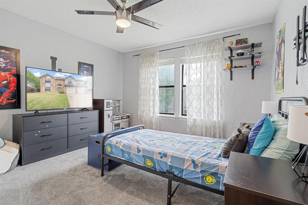 303 Hopewell Street Grand Prairie, TX 75052 - Photo 24 of 28 a bedroom with a bed and a flat screen tv