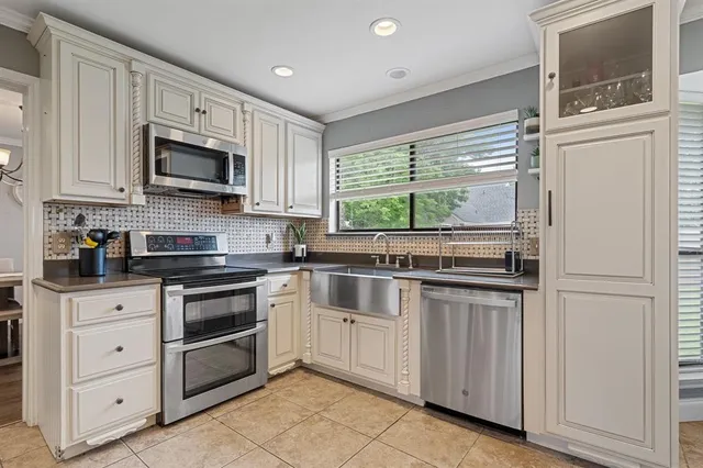 a kitchen with stainless steel appliances granite countertop a sink and a white wooden cabinets
