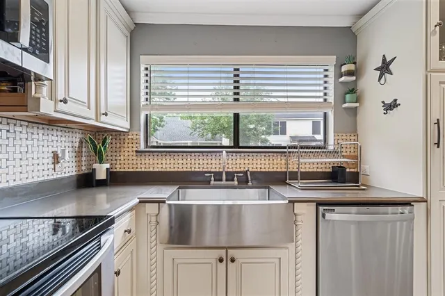 a kitchen with a table chairs microwave and cabinets