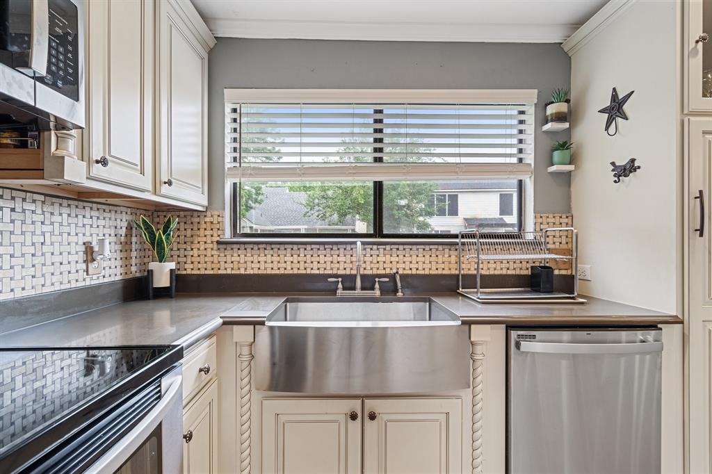 303 Hopewell Street Grand Prairie, TX 75052 - Photo 9 of 28 a kitchen with stainless steel appliances granite countertop a sink and a white wooden cabinets